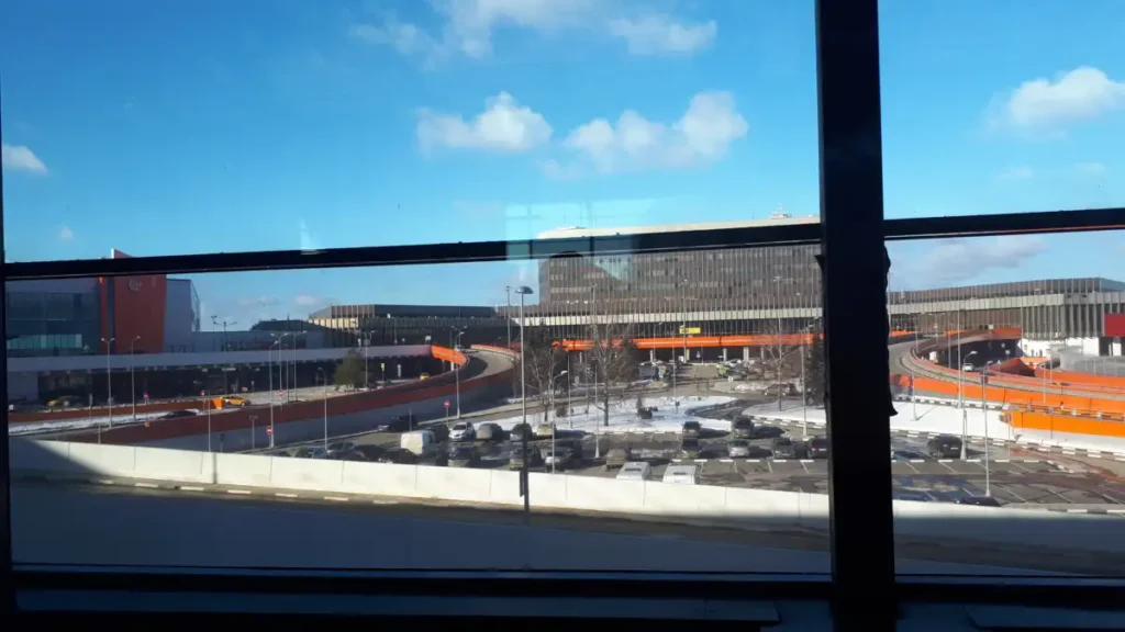 Archive view of Sheremetyevo airport buildings and access roads through terminal windows in February 2019.