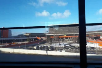 Archive view of Sheremetyevo airport buildings and access roads through terminal windows in February 2019.