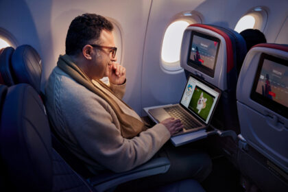 Passenger using a laptop in a Delta aircraft cabin in an archive Wi-Fi photograph