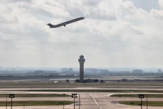 DFW control tower and airfield with an American Airlines aircraft departing, photographed in 2012