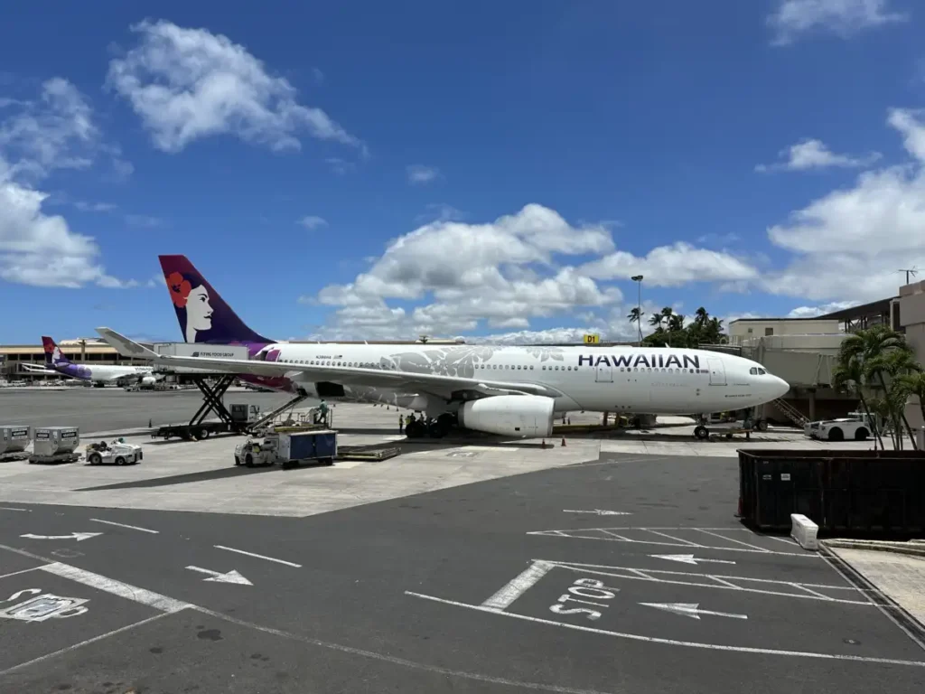 Hawaiian Airlines Airbus A330-200 on the airfield at Honolulu in June 2024, with another aircraft wing in the foreground.