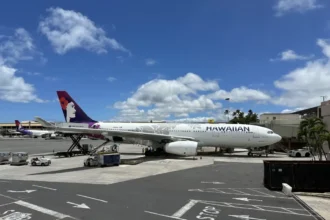 Hawaiian Airlines Airbus A330-200 on the airfield at Honolulu in June 2024, with another aircraft wing in the foreground.