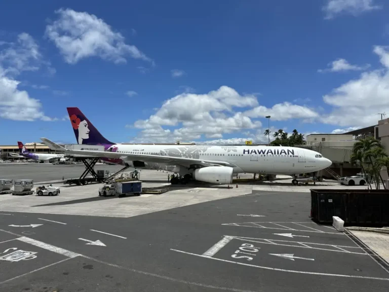 Hawaiian Airlines Airbus A330-200 on the airfield at Honolulu in June 2024, with another aircraft wing in the foreground.