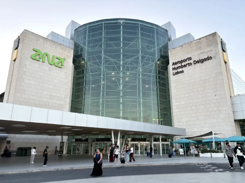 Archive photograph of Lisbon Humberto Delgado Airport’s terminal entrance in August 2026, showing its glass frontage, airport sign and pedestrians; not the São Luís launch.