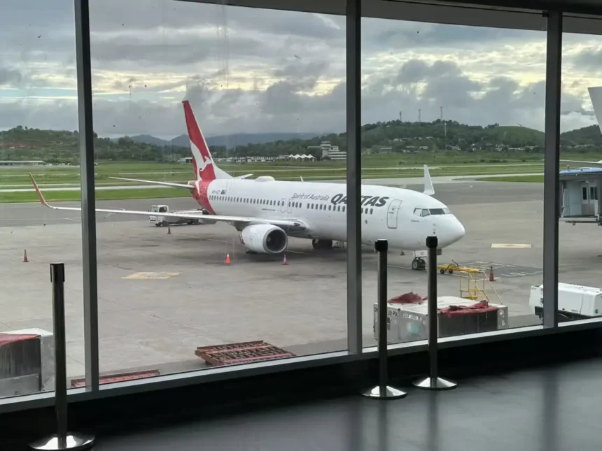 Archive Qantas Boeing 737 at a gate, seen through terminal windows in February 2025; not the Adelaide–Auckland resumption.