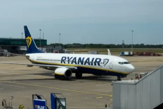 Ryanair Boeing 737 parked beside terminal boarding equipment at London Stansted Airport