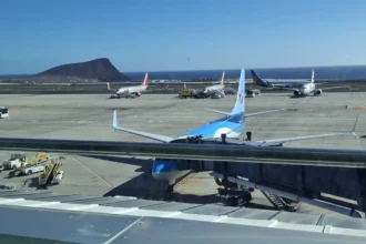 Archive view across Tenerife South Airport’s apron in December 2025, with parked aircraft, the coast and a mountain beyond; not an Air Canada inaugural flight.