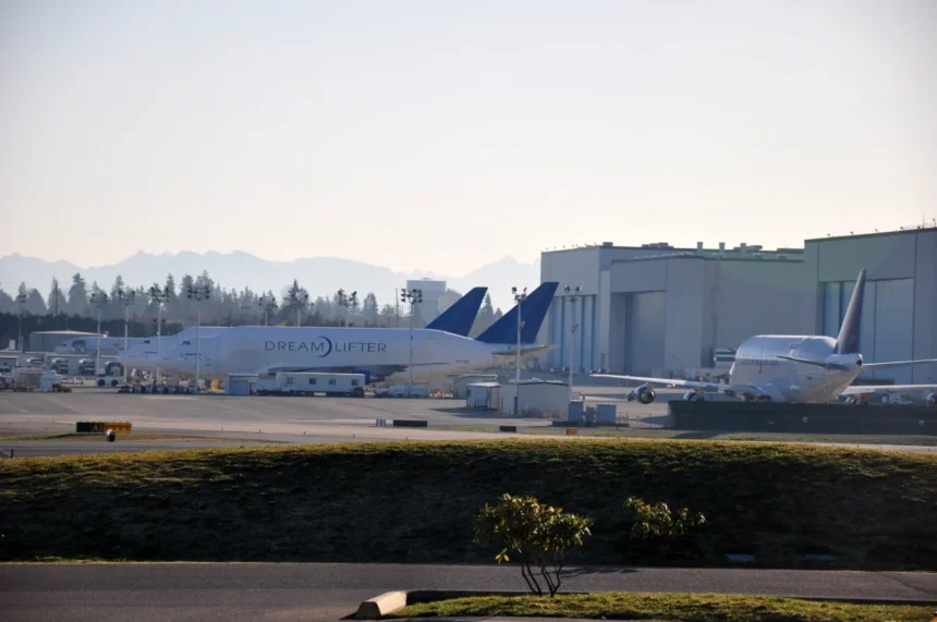 Boeing Dreamlifter cargo aircraft beside factory buildings at Everett in February 2010.
