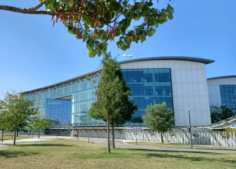 Airbus headquarters at Toulouse-Blagnac with a Beluga aircraft overhead, photographed in August 2024