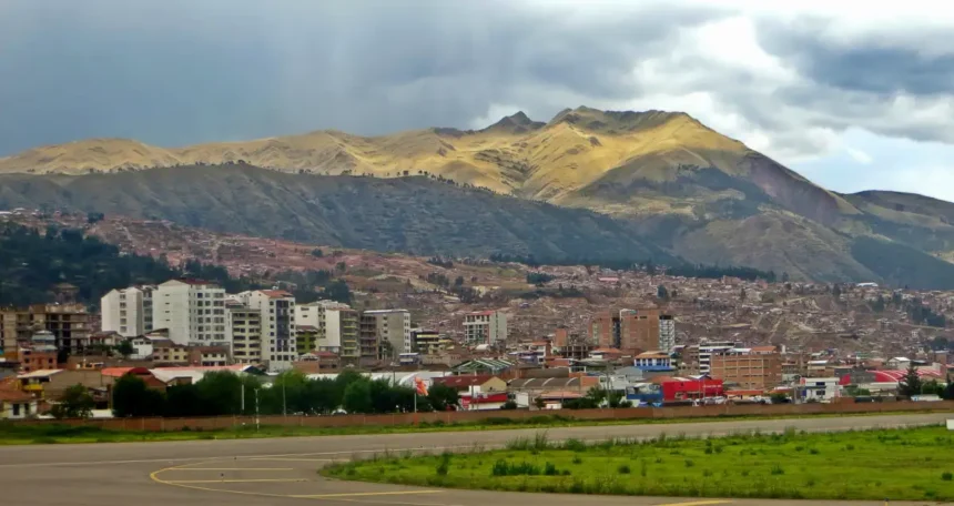 Archive view of Cusco airport pavement, city buildings and surrounding mountains in November 2018.